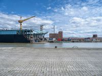 a large cargo ship is on the water's shore and docked in front of buildings