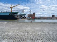 a large cargo ship is on the water's shore and docked in front of buildings