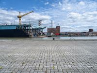 a large cargo ship is on the water's shore and docked in front of buildings