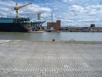 a large cargo ship is on the water's shore and docked in front of buildings