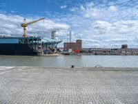 a large cargo ship is on the water's shore and docked in front of buildings