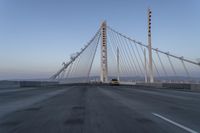 cars drive over the bridge and across it on a clear day, with blue skies above