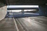 cars driving on an empty highway under a bridge at dusk or evening time time with sunlight