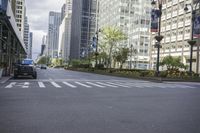 cars driving on the street in front of skyscrapers in the city by the streets with flowers