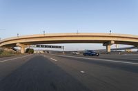 cars driving under a bridge near an overpass on the highway to a freeway bridge