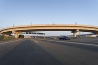 cars driving under a bridge near an overpass on the highway to a freeway bridge