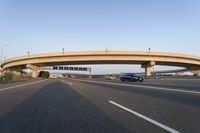 cars driving under a bridge near an overpass on the highway to a freeway bridge