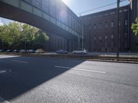 cars are parked on a city street under an overpass, as if they were in an accident