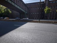 cars are parked on a city street under an overpass, as if they were in an accident