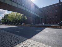 cars are parked on a city street under an overpass, as if they were in an accident