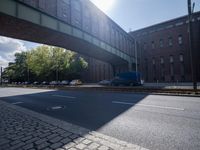 cars are parked on a city street under an overpass, as if they were in an accident