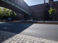 cars are parked on a city street under an overpass, as if they were in an accident