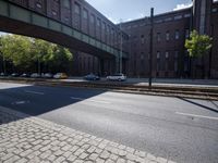 cars are parked on a city street under an overpass, as if they were in an accident