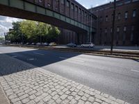 cars are parked on a city street under an overpass, as if they were in an accident