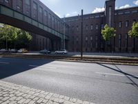 cars are parked on a city street under an overpass, as if they were in an accident