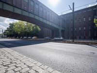 cars are parked on a city street under an overpass, as if they were in an accident
