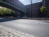 cars are parked on a city street under an overpass, as if they were in an accident