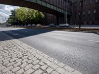 cars are parked on a city street under an overpass, as if they were in an accident