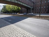 cars are parked on a city street under an overpass, as if they were in an accident