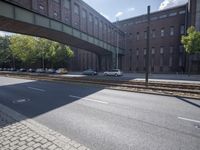 cars are parked on a city street under an overpass, as if they were in an accident