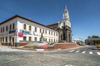 a building with an ornate white tower on top of it and a clock tower in the background