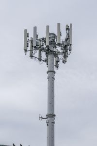 a cell phone tower with power lines and telephone towers on the roof over it,