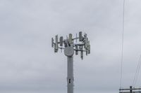 a cell phone tower with power lines and telephone towers on the roof over it,