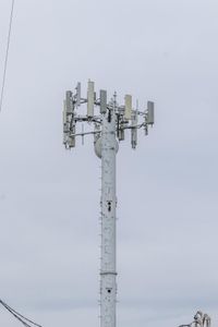 a cell phone tower with power lines and telephone towers on the roof over it,