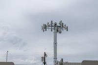 a cell phone tower with power lines and telephone towers on the roof over it,