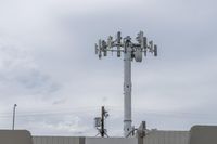 a cell phone tower with power lines and telephone towers on the roof over it,