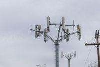 a cell phone tower with power lines and telephone towers on the roof over it,