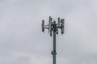 a cell phone tower with power lines and telephone towers on the roof over it,