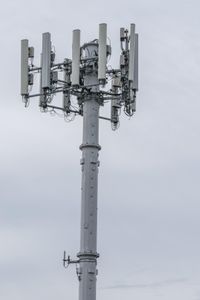 a cell phone tower with power lines and telephone towers on the roof over it,