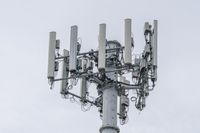 a cell phone tower with power lines and telephone towers on the roof over it,