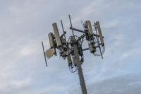 a cell phone tower with power lines and telephone towers on the roof over it,