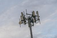 a cell phone tower with power lines and telephone towers on the roof over it,