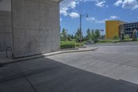 a yellow fire hydrant in the middle of a cement parking lot near tall buildings