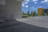 a yellow fire hydrant in the middle of a cement parking lot near tall buildings