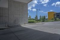 a yellow fire hydrant in the middle of a cement parking lot near tall buildings