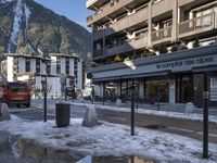 street with puddles and buildings in a ski resort area with snow on the ground