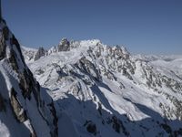 a skier going down an icy mountain side on a sunny day under the clear blue sky