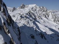 a skier going down an icy mountain side on a sunny day under the clear blue sky