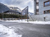 the mountains and snow covered ground are visible behind a building with a sign saying the hotel