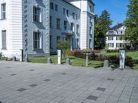 a paved area with two buildings and a red fire hydrant in the middle with no people on it