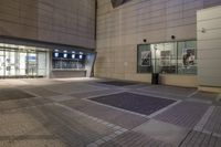 an outdoor patio at the back of a building at night with doors open in the middle