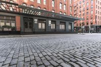 an alley in a brick city with many windows and a building on either side with a metal pergolade canopy