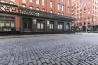 an alley in a brick city with many windows and a building on either side with a metal pergolade canopy