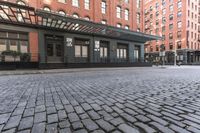 an alley in a brick city with many windows and a building on either side with a metal pergolade canopy