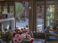 an open patio with a few chairs and flowers on the table and outside doors of the dining area