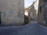 a woman with a white bag walking through an old town with stairs and buildings on either side